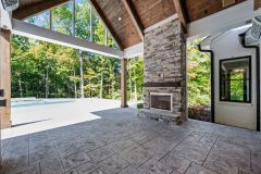 Cathedral Ceiling Covered Rear Porch With Stone Fireplace and Grilling Station