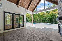 Covered Cathedral Ceiling Rear Porch With Fireplace and Pool