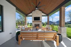 Covered Exterior Porch With Stone Fireplace and Cathedral Ceiling
