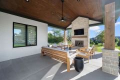 Covered Exterior Porch With Stone Fireplace and Cathedral Ceiling