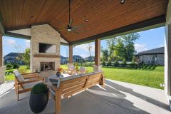 Covered Exterior Porch With Stone Fireplace and Cathedral Ceiling