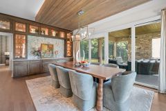 transom cabinet and marble backsplash connect the kitchen and the dining spaces