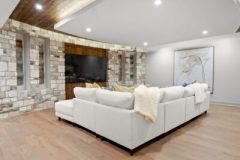 Media Room With Curved Stone Wall With Wood Accents