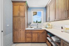Laundry Room With Window Sink and Tower Cabinetry Storage
