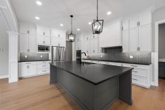 white cabinetry with dark island cabinetry with dark countertops