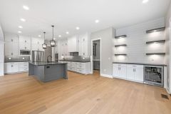 custom buffet with floating shelves and puck lighting and beverage fridge in the dining area