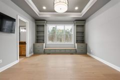 custom green built-in bookcases flanking a window seat