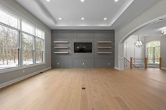  Tray Ceiling Accent Wall With Floating Modern Shelves and Open Stairway to Lower Level