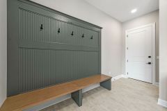 built-in bench in Mudroom with brick floor