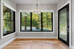 Luxury primary bedroom featuring a double tray ceiling, shallow coffered trim detail, stone fireplace and contrasting dark ceiling fan at The Vandoren custom home in Liberty Township, Ohio.