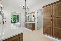 Luxury primary bathroom vanity with custom cabinetry, quartz countertops, expansive mirror, and makeup area at The Vandoren custom home in Liberty Township, Ohio.