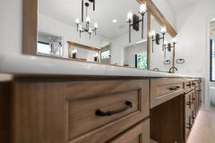 Luxury primary bathroom vanity with custom cabinetry, quartz countertops, expansive mirror, and makeup area at The Vandoren custom home in Liberty Township, Ohio.