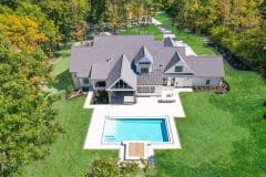 Aerial view of Liberty Twp Custom home with rear covered porch and pool-The Vandoren