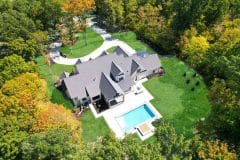 Aerial view of Liberty Twp Custom home with circular driveway, rear covered porch and pool-The Vandoren