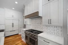 The Kitchen hood with white cabinetry and wood accent - The Vandoren