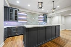 Pendant lighting with custom cabinetry storage lower level pub style bar