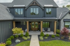 Custom home dark exterior with cedar pillars and metal roof