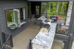 Custom home covered porch cathedral ceilings pass through window  and stone fireplace