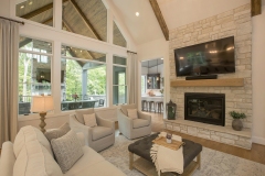 Great Room with cathedral ceiling beams and first floor bar and view of outdoor living space