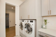 custom home laundry with open and closed storage