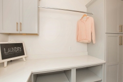 custom home laundry with open and closed storage