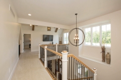 loft or bonus room with cathedral ceiling overlooking staircase