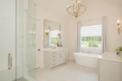 custom home primary suite with his and her vanities
