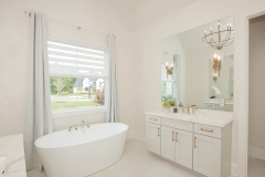 custom home primary suite with his and her vanities