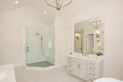 custom home primary suite with his and her vanities and large walk-in shower
