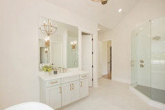 custom home primary suite with his and her vanities
