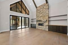 Great Room With Stone Fireplace and Access To Covered Screened-In Porch