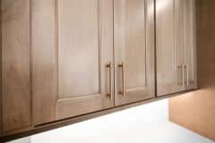 Stained Wood Cabinetry With Gold Accent Hardware