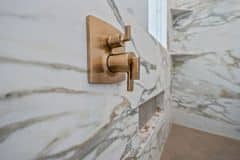 Gold Plumbing Accents in the Primary Shower