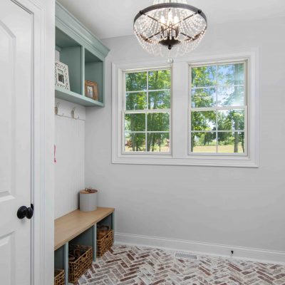 mud room with herringbone brick floor