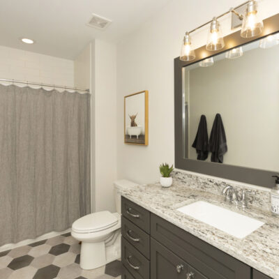 Lower Level Bathroom with Custom Cabinetry and Framed Mirror
