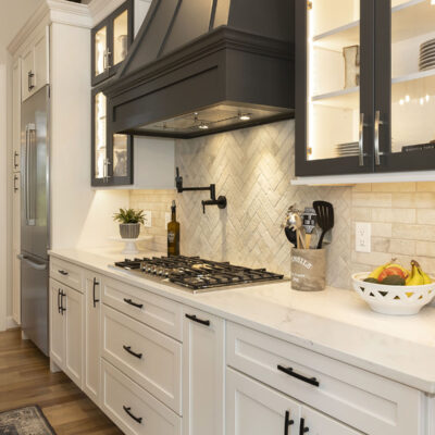 White Kitchen Cabinetry with Glass Black framed Doors and Hood