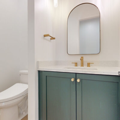 Powder Room with green custom cabinetry and gold accents