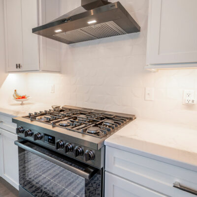Modern Kitchen with Appliance Hood and Textured Ceramic Tile Backsplash