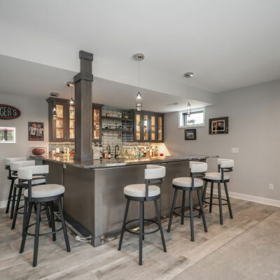 Lower Level Bar with Custom Cabinetry, Integrated Lighting and Mirror Backsplash