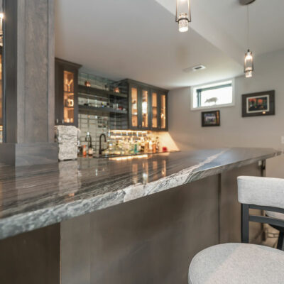 Lower Level Bar with Custom Cabinetry, Integrated Lighting and Mirror Backsplash