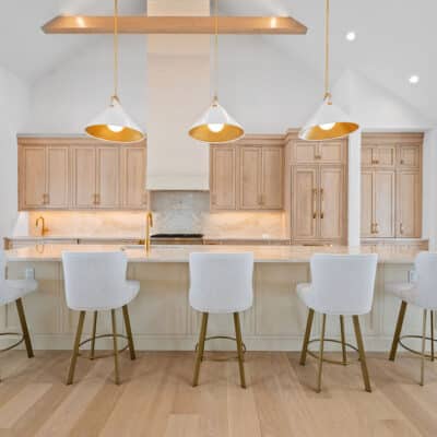 Large Island in Kitchen with 2 cabinet colors and large island and backsplash using Taj Mahal granite with suspended white oak truss beams