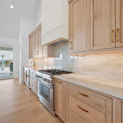 Kitchen with 2 cabinet colors and large island and backsplash using Taj Mahal granite