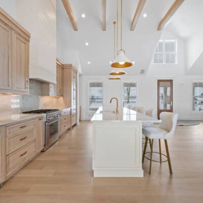 Kitchen with 2 cabinet colors and large island and backsplash using Taj Mahal granite