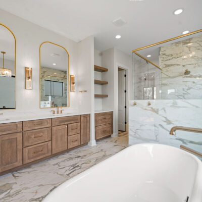 double sink vanity with built-in white oak cabinetry and brushed gold fixtures