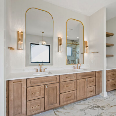 double sink vanity with built-in white oak cabinetry and brushed gold fixtures
