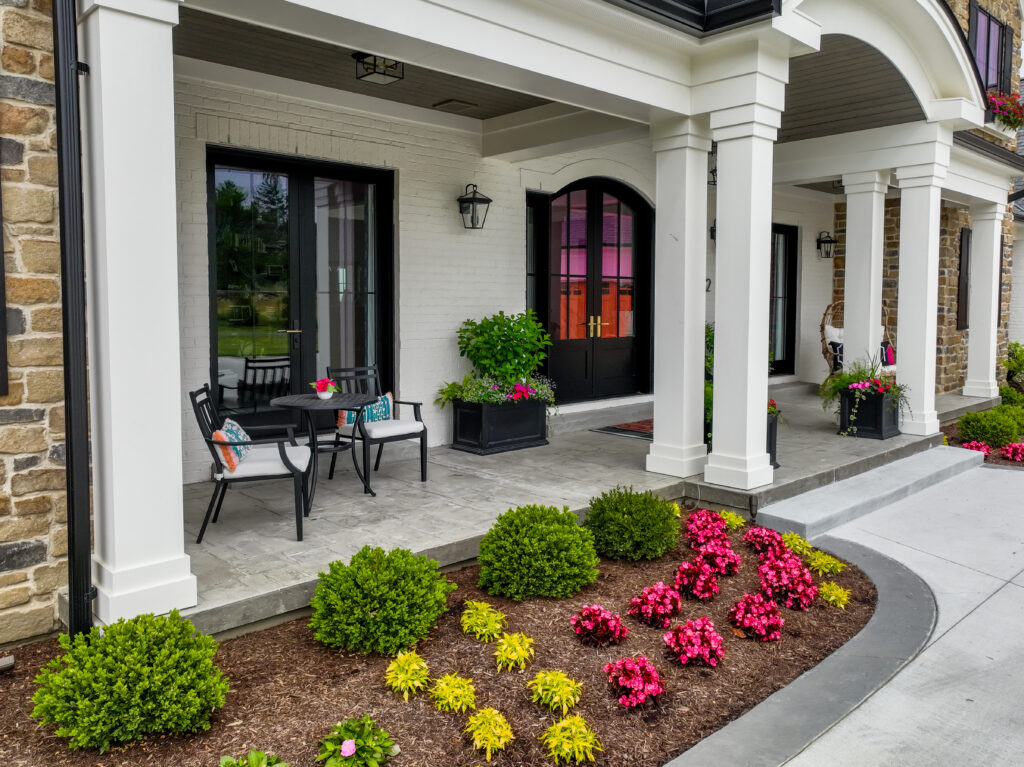Covered front porch with flower beds and window boxes