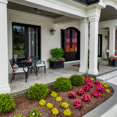 Covered front porch with flower beds and window boxes