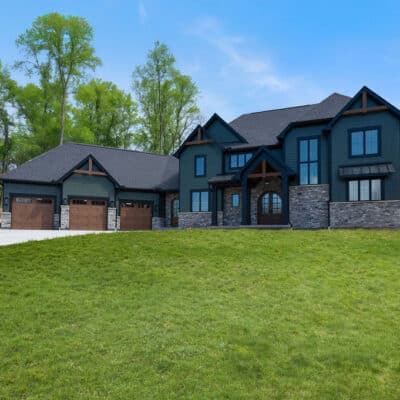 Two Story Custom Home Cleaves Stone Dark Green Siding Stone and Cedar Accents