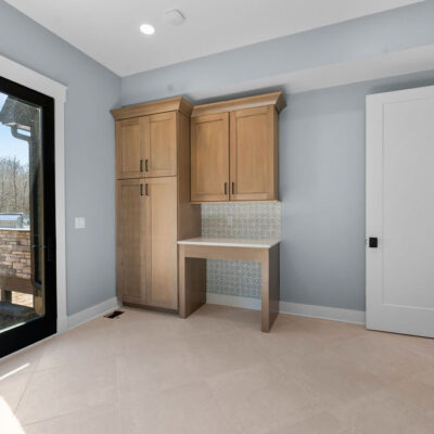 Wood Stained Cabinetry In Laundry with Pet Spaces Exterior Glass Door to Backyard