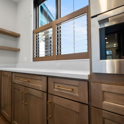 Custom Kitchen With Stained Cabinetry, Quartz Countertops and Hidden Pantry